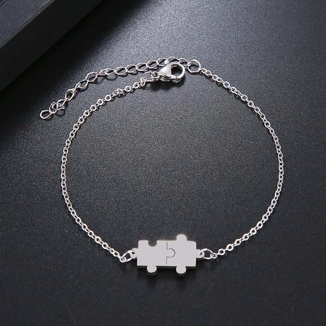 Nemesacél puzzle motívumos állítható méretű női karkötő, ezüst színű